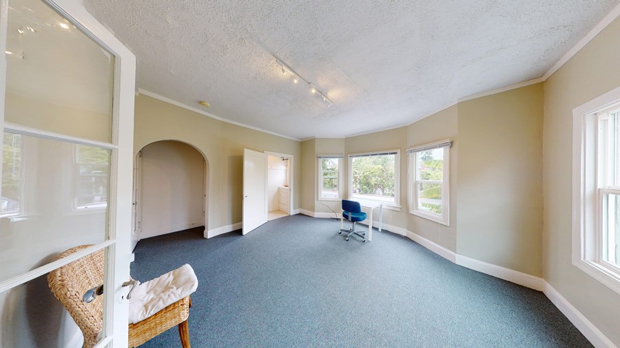 A room with a blue carpet and a chair.